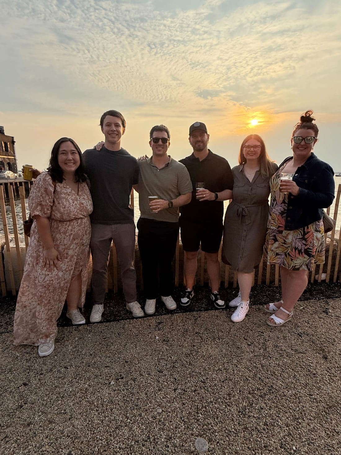 Team gathered at sunset by the water
