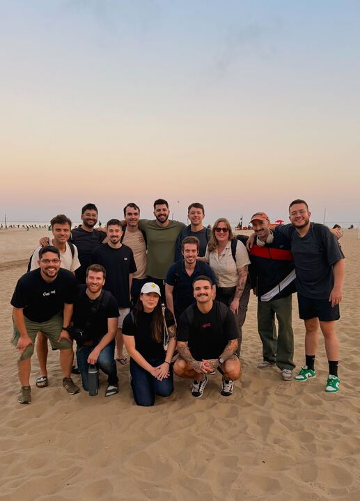 The full team on the beach at sunset